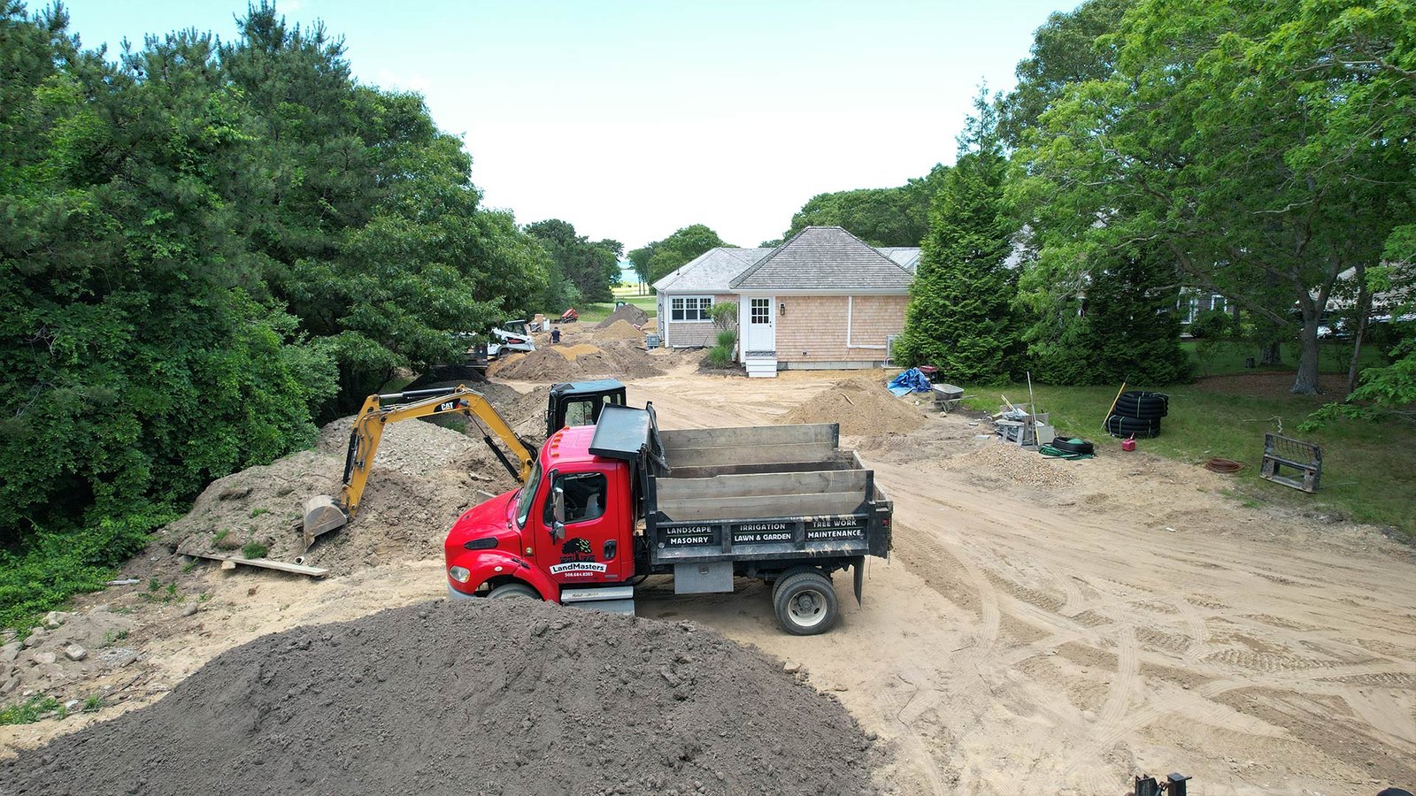 LandMasters truck and CAT excavator at Oak Bluffs estate site preparation, Martha's Vineyard